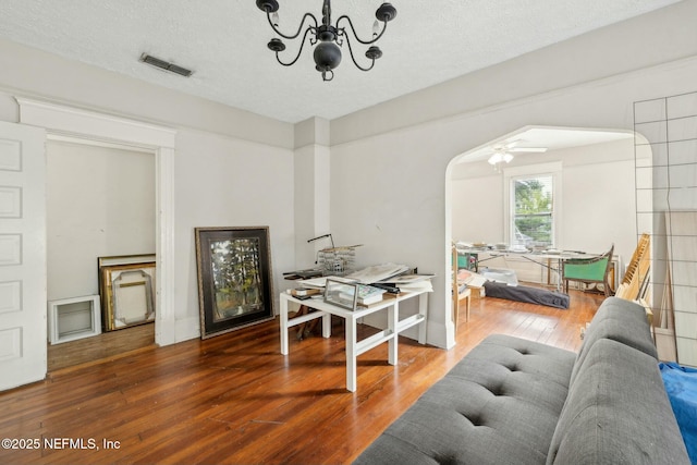 2234 Forbes St, Jacksonville, FL 32204 - living room featuring hardwood / wood-style floors, an inviting chandelier, visible vents, arched walkways, and a textured ceiling