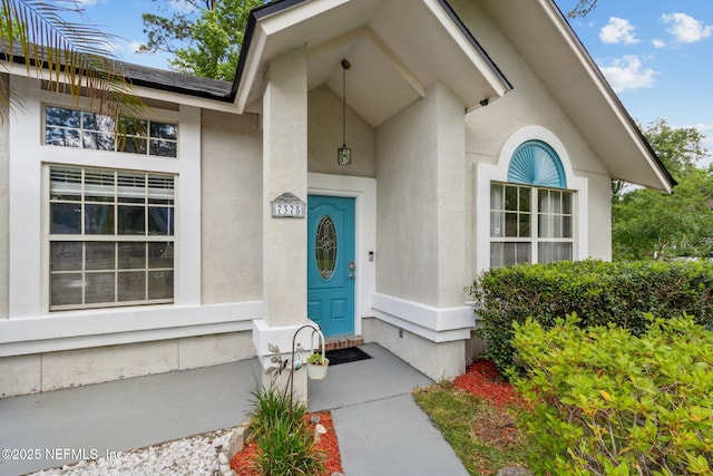 view of exterior entry with stucco siding