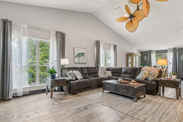 living area with visible vents, light wood-style flooring, a ceiling fan, and lofted ceiling