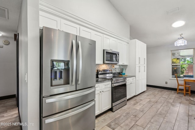 kitchen with visible vents, stainless steel appliances, white cabinets, and backsplash