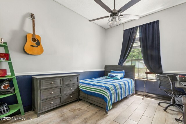 bedroom with a ceiling fan and light wood-style flooring