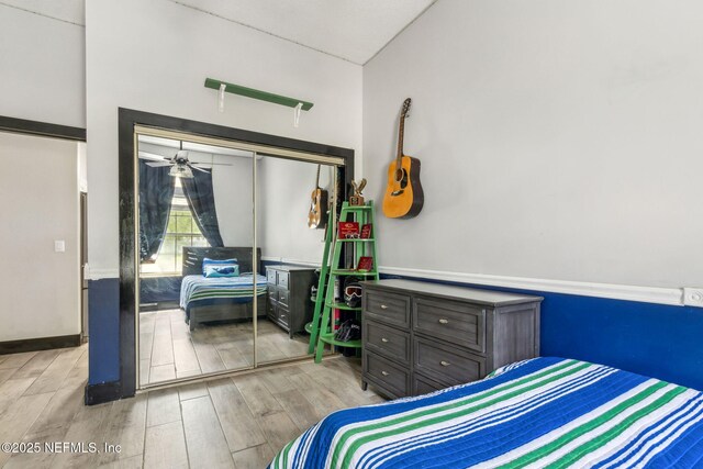 bedroom with wood finished floors and a closet