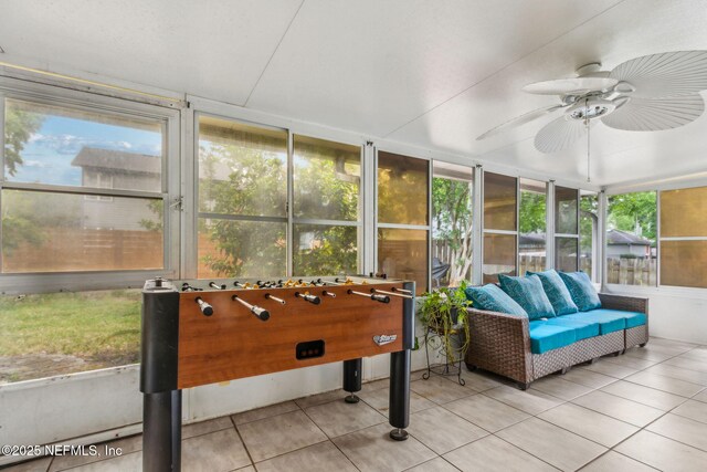 sunroom / solarium with outdoor lounge area, tile patterned flooring, and a ceiling fan