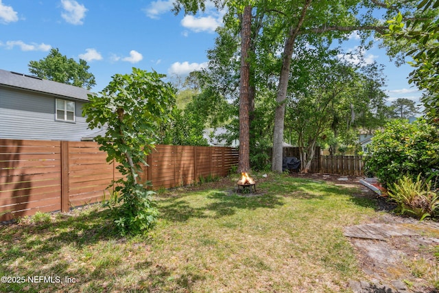 view of yard with an outdoor fire pit and a fenced backyard