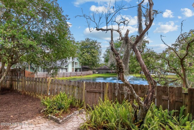 view of yard featuring fence and a water view