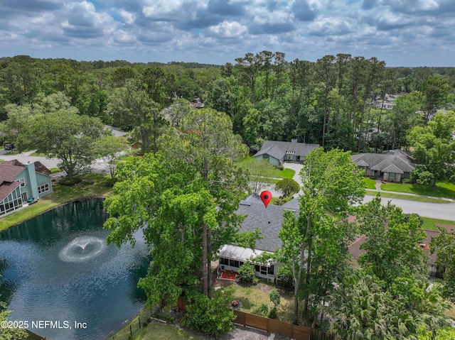 drone / aerial view with a wooded view and a water view