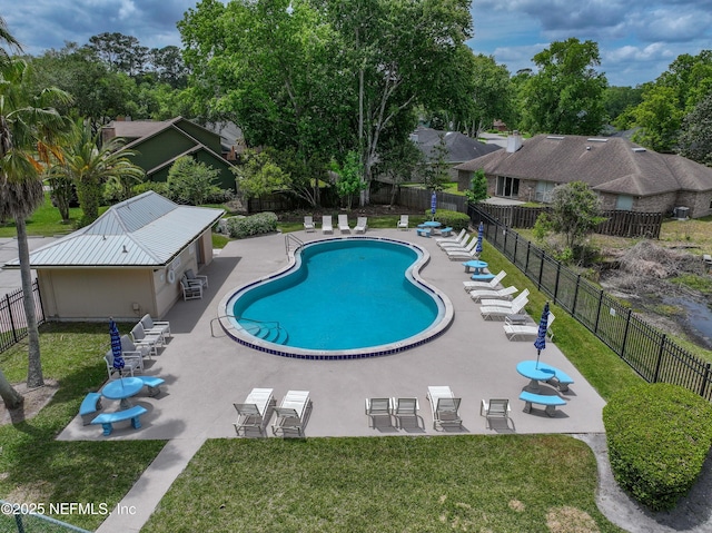 community pool featuring fence, a patio area, and a lawn