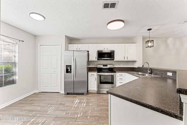 1605 Vineland Cir Unit B, Fleming Island, FL 32003 - kitchen with white cabinets, dark countertops, visible vents, a sink, and appliances with stainless steel finishes