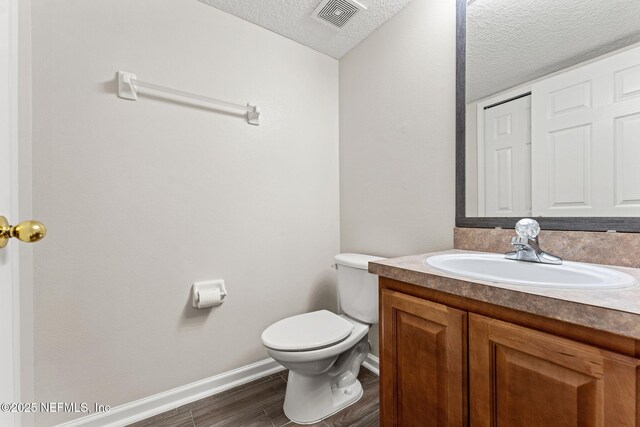 1605 Vineland Cir Unit B, Fleming Island, FL 32003 - bathroom featuring visible vents, toilet, vanity, baseboards, and a textured ceiling