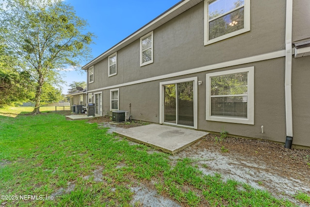 1605 Vineland Cir Unit B, Fleming Island, FL 32003 - back of property with stucco siding, a lawn, a patio, and central AC unit