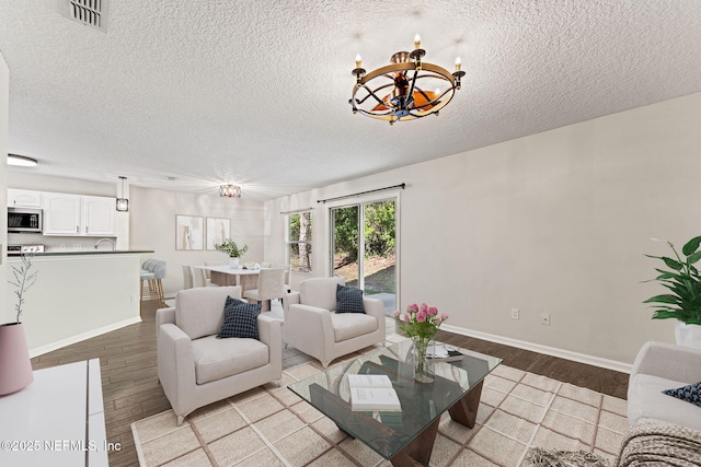 1605 Vineland Cir Unit B, Fleming Island, FL 32003 - living room with light wood finished floors, visible vents, a textured ceiling, and a chandelier