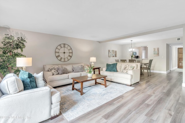 7908 Los Robles Ct Unit 7908, Jacksonville, FL 32256 - living room featuring baseboards, light wood-type flooring, visible vents, and an inviting chandelier