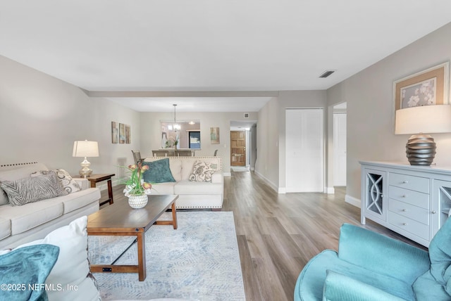 7908 Los Robles Ct Unit 7908, Jacksonville, FL 32256 - living area with a notable chandelier, visible vents, baseboards, and light wood-style floors