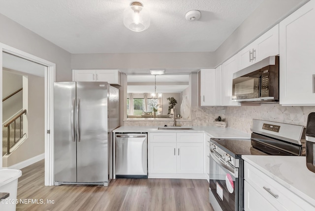 7908 Los Robles Ct Unit 7908, Jacksonville, FL 32256 - kitchen featuring appliances with stainless steel finishes, light wood-style floors, light countertops, and a sink