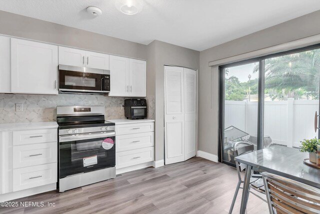 7908 Los Robles Ct Unit 7908, Jacksonville, FL 32256 - kitchen featuring white cabinets, stainless steel appliances, light countertops, and decorative backsplash