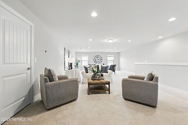 carpeted living area featuring recessed lighting and baseboards