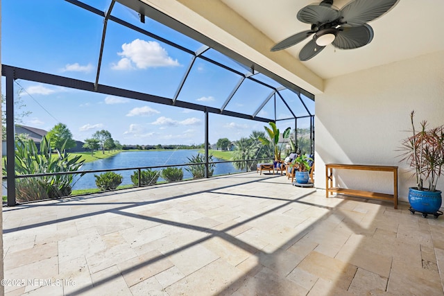view of patio / terrace with glass enclosure, a water view, and a ceiling fan