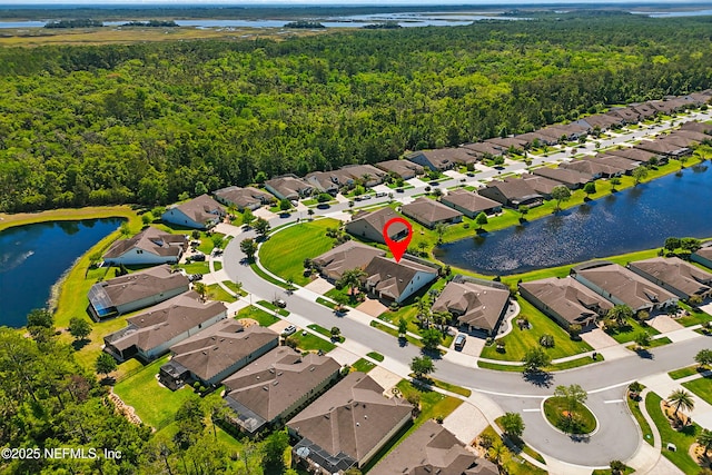 bird's eye view with a residential view, a view of trees, and a water view