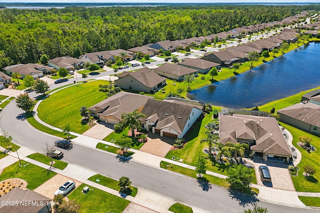 aerial view featuring a water view, a view of trees, and a residential view