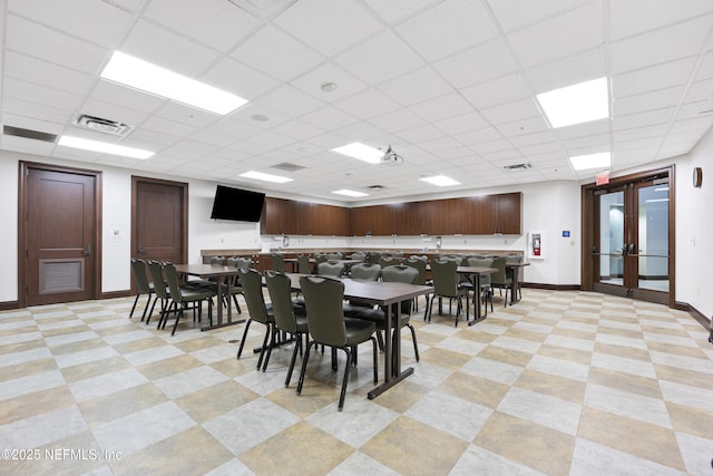 dining space featuring visible vents, baseboards, a drop ceiling, and french doors