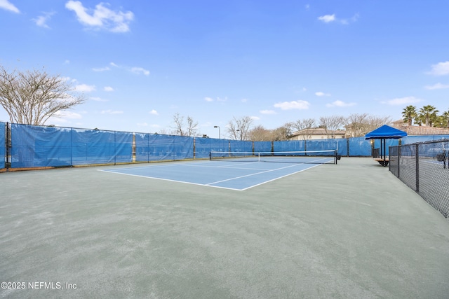 view of tennis court featuring fence