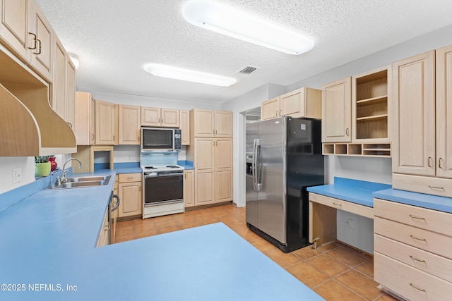 2848 Cedarcrest Dr, Orange Park, FL 32073 - kitchen with light brown cabinets, a textured ceiling, a sink, light tile patterned flooring, and stainless steel appliances