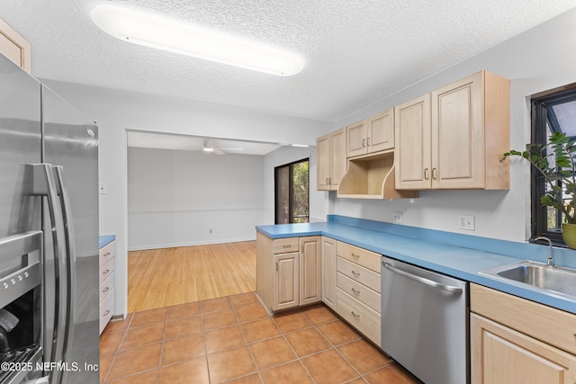 2848 Cedarcrest Dr, Orange Park, FL 32073 - kitchen with light brown cabinetry, light tile patterned floors, a sink, a textured ceiling, and appliances with stainless steel finishes