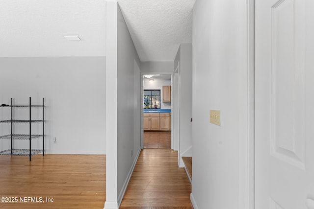2848 Cedarcrest Dr, Orange Park, FL 32073 - corridor with light wood-style flooring, baseboards, and a textured ceiling