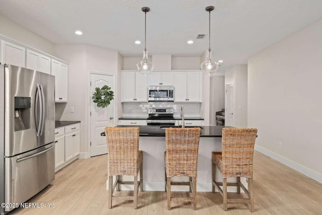 kitchen featuring white cabinets, dark countertops, visible vents, and stainless steel appliances