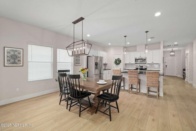 dining area with light wood finished floors, baseboards, recessed lighting, and visible vents