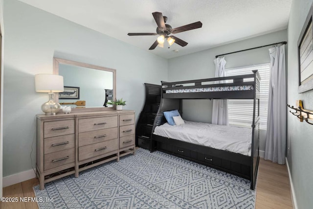 bedroom featuring ceiling fan, baseboards, and light wood-style flooring