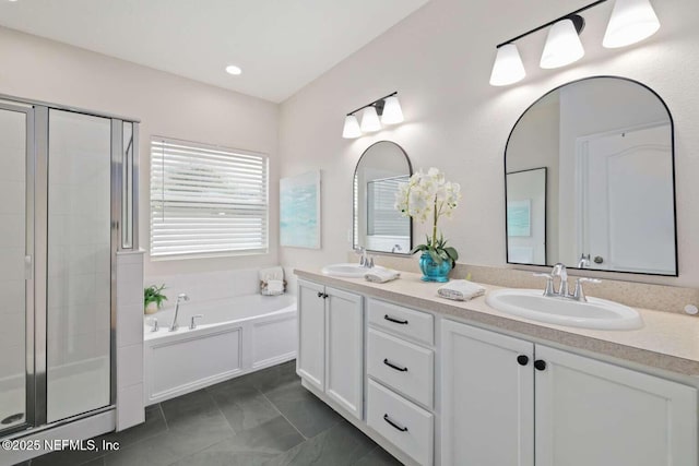 bathroom with a bath, a sink, double vanity, and a stall shower