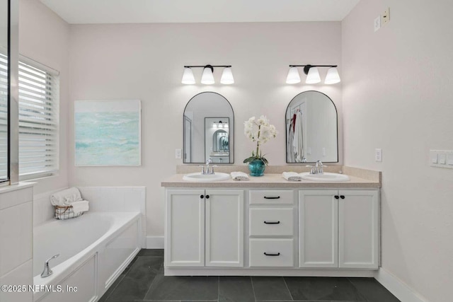 full bath featuring baseboards, tile patterned flooring, a sink, and double vanity
