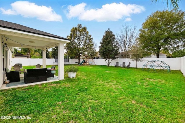 view of yard featuring a patio area, a fenced backyard, and a playground