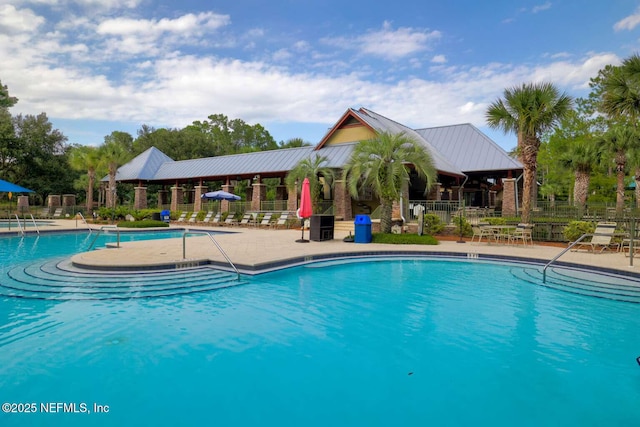 community pool with fence and a patio
