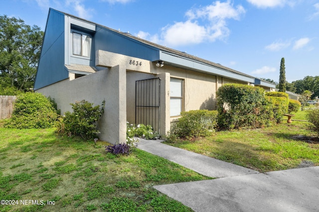 8634 Greatpine Ln W, Jacksonville, FL 32244 - view of property exterior featuring fence, a yard, and stucco siding