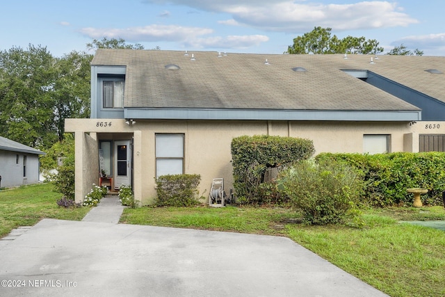 8634 Greatpine Ln W, Jacksonville, FL 32244 - view of front of property with a shingled roof, a front lawn, and stucco siding