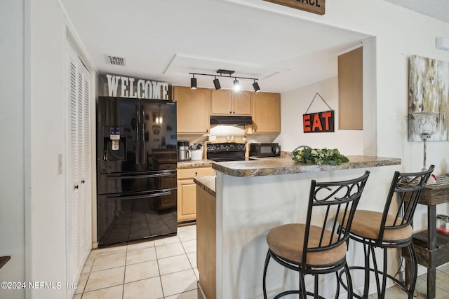 8634 Greatpine Ln W, Jacksonville, FL 32244 - kitchen with light brown cabinetry, visible vents, under cabinet range hood, rail lighting, and black appliances