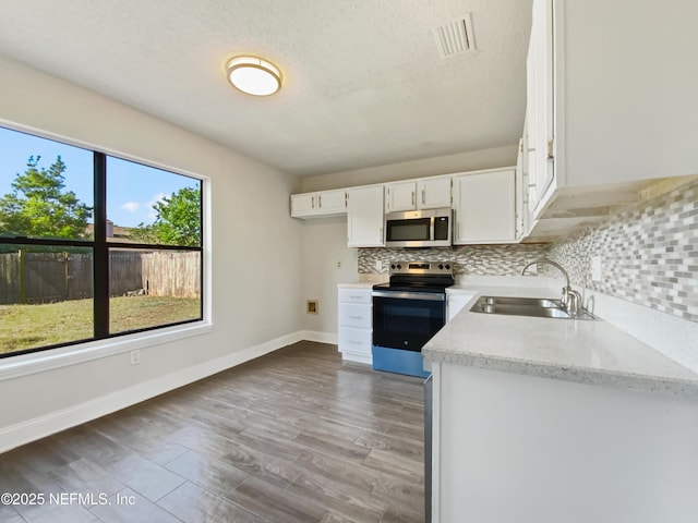 3444 Excalibur Way E, Jacksonville, FL 32223 - kitchen with visible vents, a sink, appliances with stainless steel finishes, and tasteful backsplash