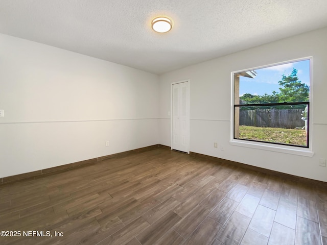 3444 Excalibur Way E, Jacksonville, FL 32223 - empty room with dark wood-type flooring, a textured ceiling, and baseboards
