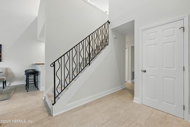 staircase featuring visible vents, baseboards, and wood finished floors
