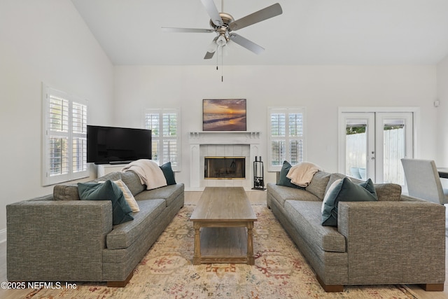 living area featuring a wealth of natural light, a ceiling fan, french doors, and wood finished floors