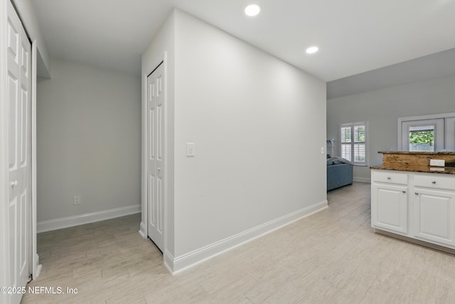 hall featuring recessed lighting, light wood-style flooring, and baseboards