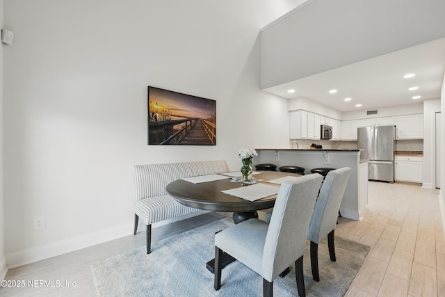 dining area with recessed lighting, light wood-type flooring, visible vents, and baseboards
