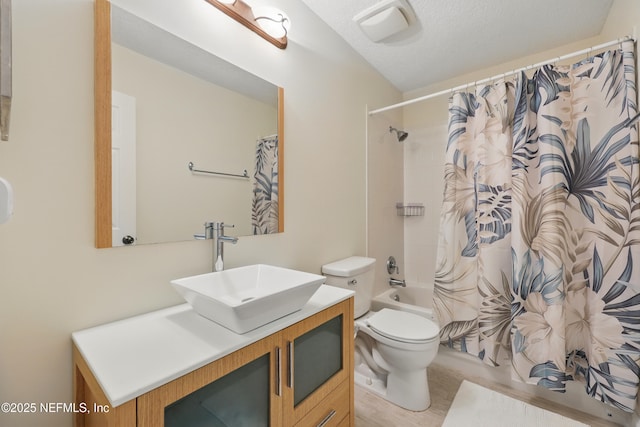 bathroom with a textured ceiling, toilet, vanity, and shower / bathtub combination with curtain