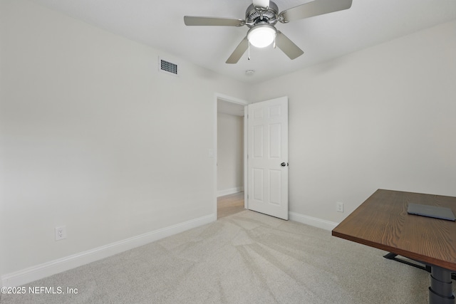 unfurnished office featuring carpet flooring, baseboards, visible vents, and ceiling fan