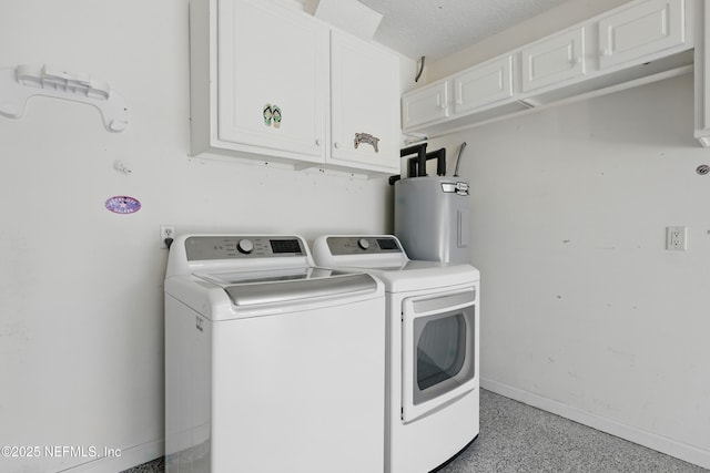 laundry room featuring washing machine and clothes dryer, baseboards, water heater, and cabinet space