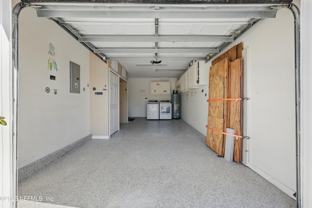 garage featuring baseboards, electric water heater, electric panel, and independent washer and dryer