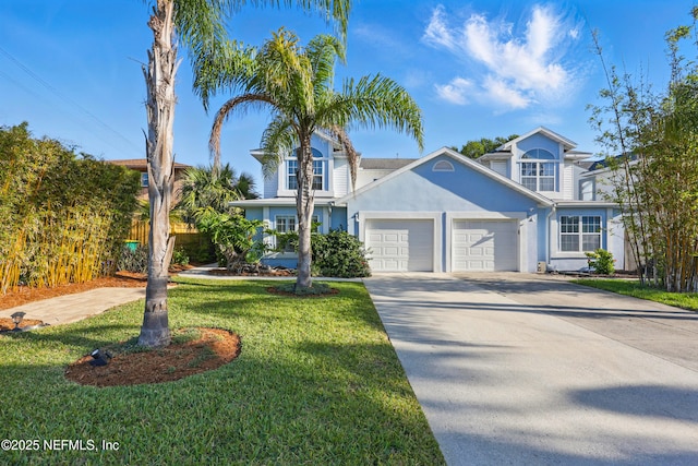 view of front of home with a garage, driveway, fence, a front yard, and stucco siding
