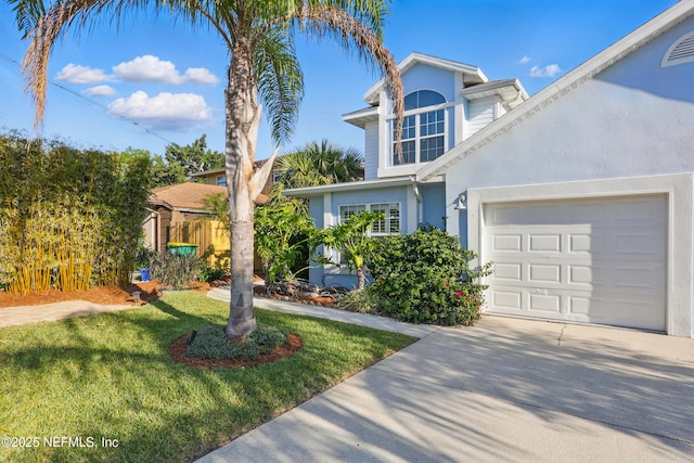 traditional-style home with stucco siding, a front lawn, driveway, and a garage